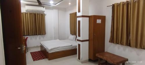 a small bedroom with a small bed and a window at Hotel Shree Elite in Ratlām