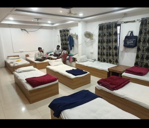 a group of beds in a room with people in it at Hotel Shree Elite in Ratlām