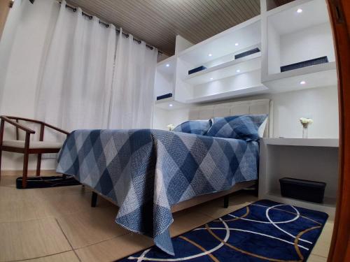 um quarto com uma cama com um edredom azul e branco em Recanto do Sossego em Águas de Lindóia