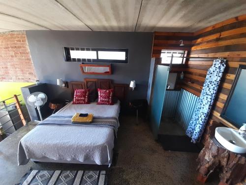 The Regiment Self Catering Accommodation has 3 x 4 sleeper units في Welgemoed: غرفة نوم بسرير ومغسلة