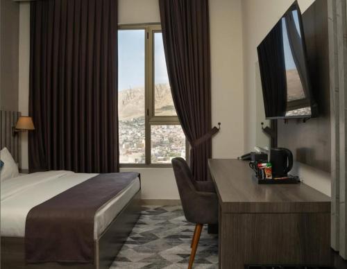 代胡克Wan Hotel的一间带床、书桌和窗户的酒店房间