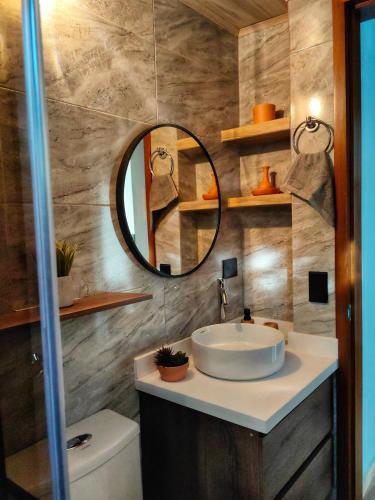 a bathroom with a sink and a mirror at Hospedandote Emuná Chicamocha in Los Santos