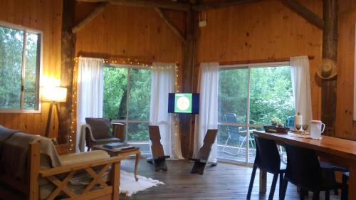 een woonkamer met een televisie en een tafel en stoelen bij El octógono in Tigre