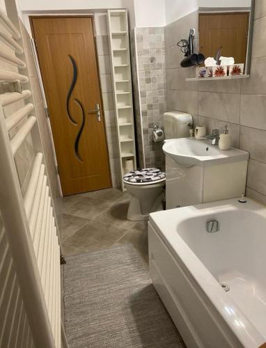 ein Badezimmer mit Toilette und Waschbecken und einer Tür in der Unterkunft Lemora Apartments 2 in Focşani