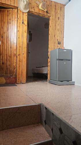 阿加迪尔Room的一间带冰箱的厨房,位于带木墙的客房内