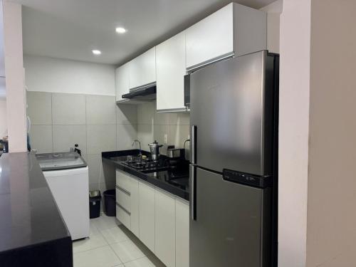 eine Küche mit einem Kühlschrank aus Edelstahl in der Unterkunft Cabo de Santo Agostinho Apartmento in Cabo de Santo Agostinho