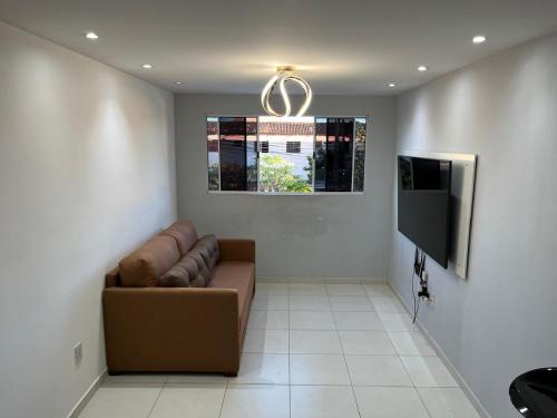 ein Wohnzimmer mit Sofa und Flachbildfernseher in der Unterkunft Cabo de Santo Agostinho Apartmento in Cabo de Santo Agostinho