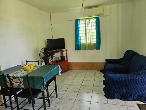 a living room with a table and chairs and a television at Célia in Matoury