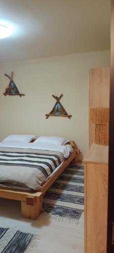 ein Schlafzimmer mit einem Bett und einer Wand mit Kreuzen darauf in der Unterkunft Casa AyA Colibita in Colibiţa