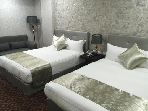 a hotel room with two beds and a couch at Chi Shing Hai Hotel in Dahan