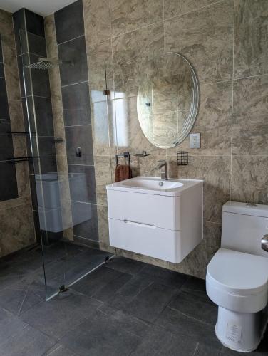 a bathroom with a toilet and a sink and a mirror at Casa Playa Eugen beach house with pool in El Morro