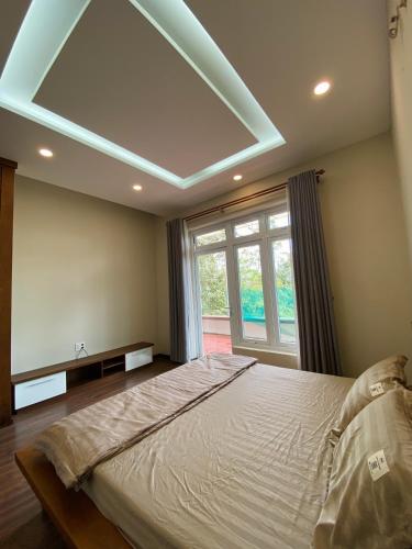 a bedroom with a large bed with a large window at Xù Gia Trang in Konteh Sre Pong