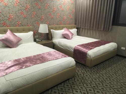 a hotel room with two beds with pink pillows at Chi Shing Hai Hotel in Dahan