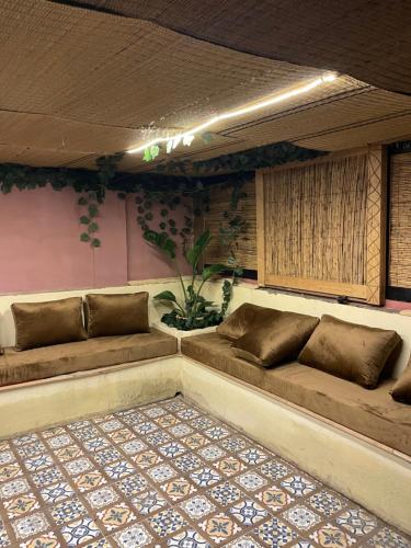 ein Zimmer mit zwei braunen Sofas in einem Zimmer in der Unterkunft Zeri Surf Camp in Tiguemmi nʼAït Bihi