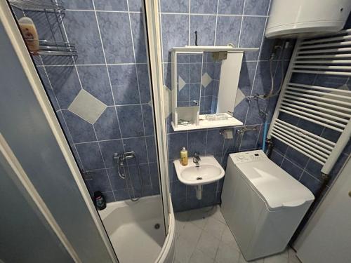 un bagno piastrellato blu con lavandino e WC di Orient Apartment Old Town a Sarajevo