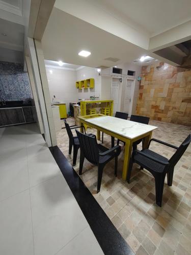 Ruta Amazônica Hostel في بيليم: غرفة طعام بها طاولة وكراسي