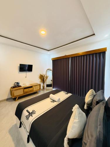 a bedroom with a large bed and a television at Talvista Kintamani Villa in Kintamani