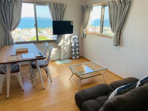 a living room with a table and a couch at Guest House Marine View - Vacation STAY 62152v in Uruma