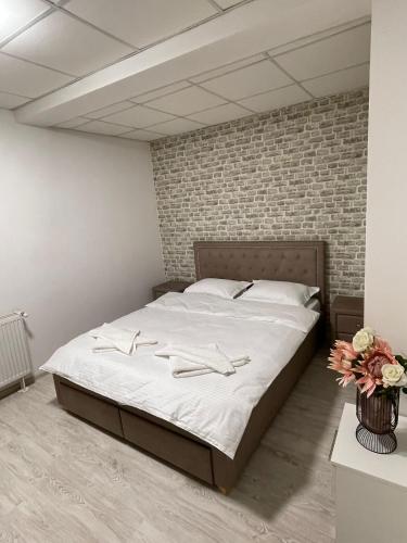 a large bed in a room with a brick wall at Apartament cu 5 camere in Craiova