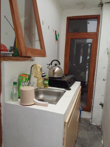 a kitchen with a sink and a tea kettle on the counter at Homestay Tata in Bugisan