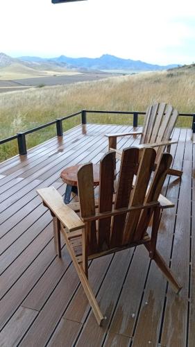 zwei Stühle auf einer Holzterrasse in der Unterkunft Finca Ocho Cerros in Tornquist