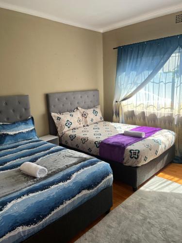 a bedroom with two beds and a window at Ridah's Accomodation in Bellville
