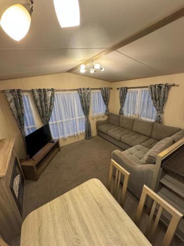 Kinmel Bay3 bedroom Lyons Oakfield Towyn pets welcome的客厅里有一张沙发和一台电视