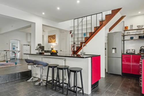 a kitchen with a counter and stools in it at The Regents Park Townhouse in London