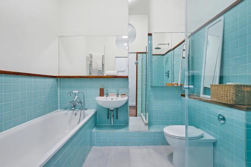 a bathroom with a tub sink and a toilet at The Regents Park Townhouse in London