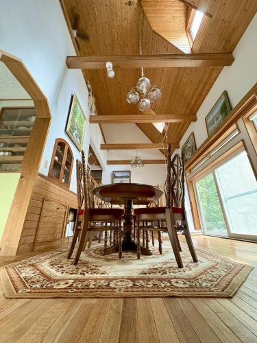 a dining room with a wooden table and chairs at Mountain chalet getaway at Fuji-Sanroku 富士山麓のシャレー風山荘 in Narusawa