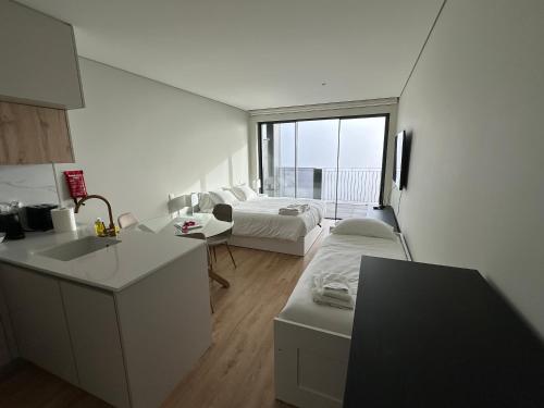 a kitchen and living room with a bed and a sink at New Douro Tower 305 with shared pool in Vila Nova de Gaia