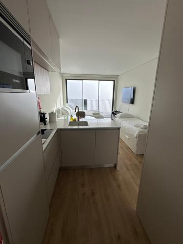 a kitchen with a sink and a refrigerator in a room at New Douro Tower 305 with shared pool and parking in Vila Nova de Gaia