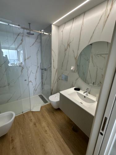a bathroom with a sink and a toilet and a shower at New Douro Tower 305 with shared pool in Vila Nova de Gaia