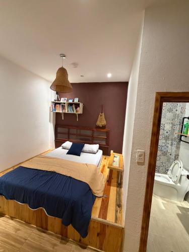 a bedroom with a large bed and a bathroom at Hostel-John Cafe and Beer in Da Lat