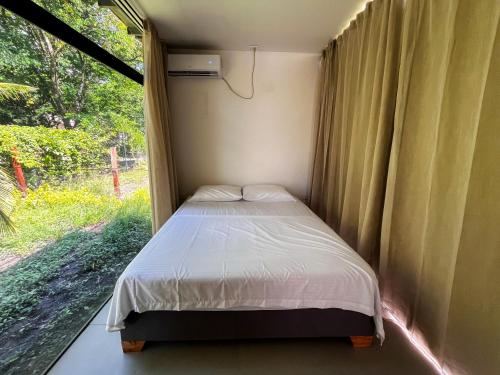 Bett in einem kleinen Zimmer mit Fenster in der Unterkunft Cabaña de campo la MariaCa in Utica