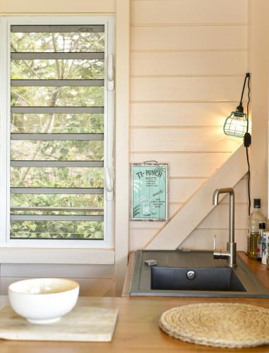 a kitchen with a window and a sink at La poolhouse in Grand-Bourg