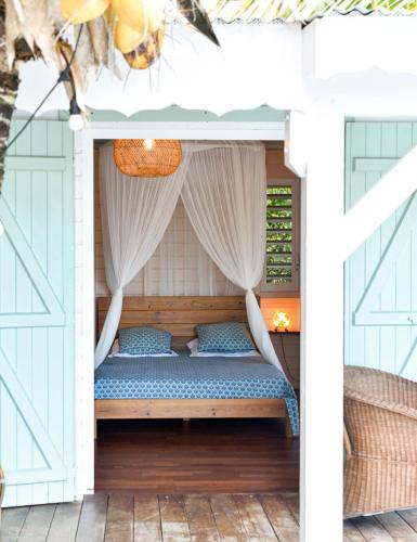 a bed in a pergola on a patio at La poolhouse in Grand-Bourg