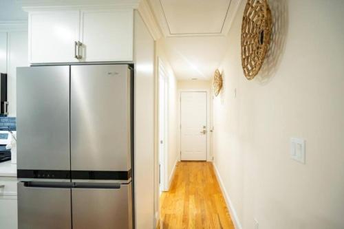 a kitchen with a stainless steel refrigerator and a hallway at 80-3 3BR Boston - Cozy Apt near Dorchester Center in Boston