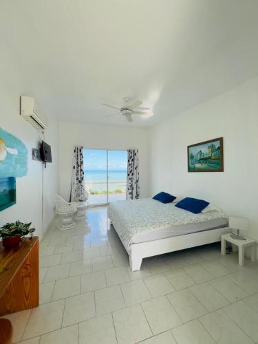 a white bedroom with a bed and a window at Hotel La Loma in Miches