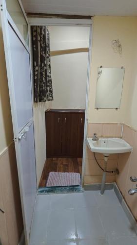 a small bathroom with a sink and a mirror at Madhurleela Villa in Alibaug