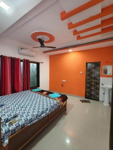 a bedroom with a bed in a room with orange walls at Divyesh Holiday Home in Nagaon