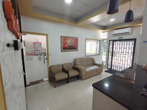 a living room with a couch and a table and a kitchen at Hotel Val-de-Cans Aeroporto in Belém