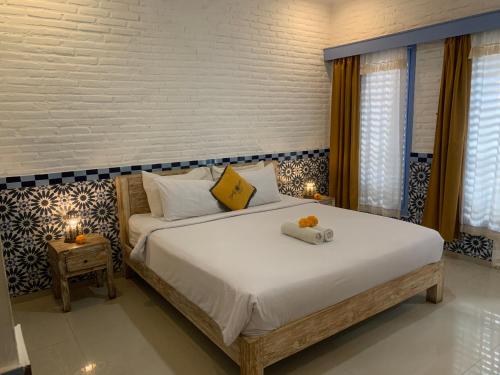 a bedroom with a large bed with two pillows on it at Sunflower Stay And Surf in Canggu