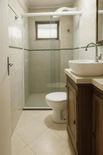 a bathroom with a shower and a toilet and a sink at Refúgio com Varanda, Wi-Fi Rápido, 450m da Praia, seu Cantinho em BC in Balneário Camboriú