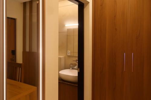 Un baño con un lavabo blanco y un espejo. en The Miste Munnar By D2V, en Munnar