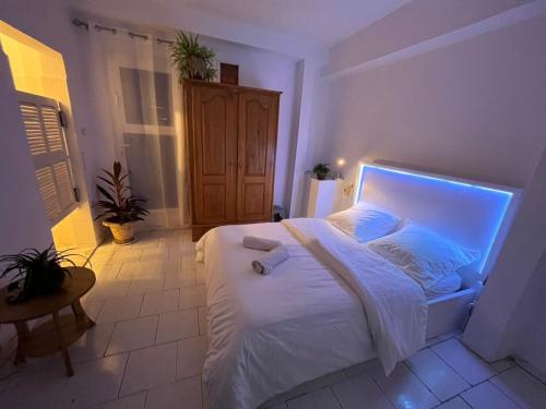 a bedroom with a white bed with a light on it at Chambre double in Mbour