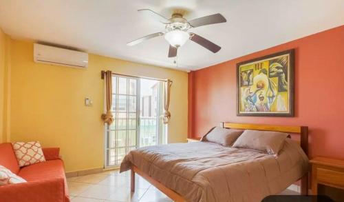 Un dormitorio con una cama y un ventilador de techo. en Paradise suites &residence, en San Pedro