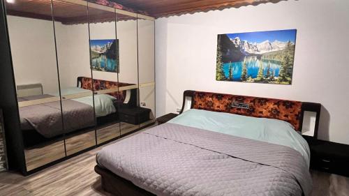 1 dormitorio con cama y pared de espejo en Haus Romsicht Karinthië, en Kerschdorf