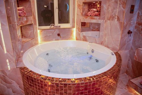 a bathroom with a large tub with lights in it at Velmora Apartments in Huddersfield
