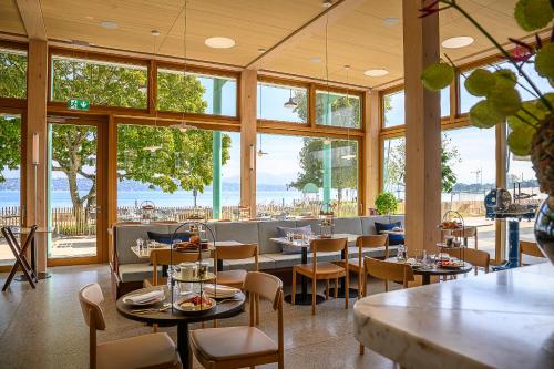 a restaurant with tables and chairs and large windows at Auberge Port Gitana in Bellevue